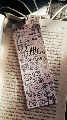 a bookmark with the words love on it sitting on top of an open book