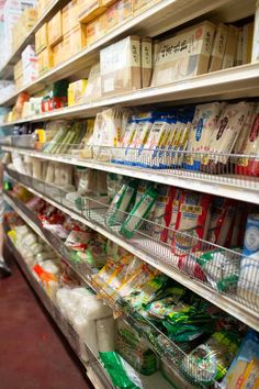 shelves in a grocery store filled with milk, eggs and other food items for sale