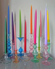 there are many different colored candles on the table