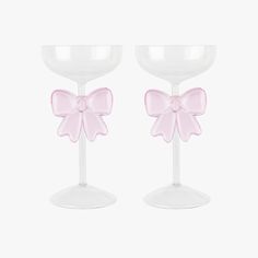 two wine glasses with pink bows on them