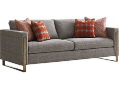 a gray couch with orange and white pillows on it's back end, against a white background