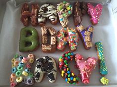 a box filled with lots of different types of doughnuts in the shape of letters