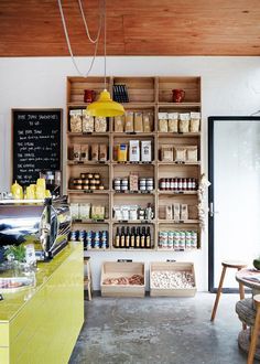 an open kitchen with lots of food on the counter and shelves filled with condiments