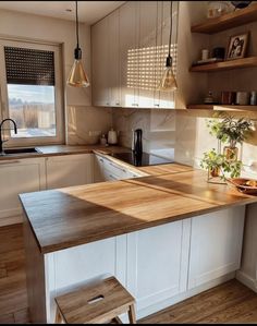 a kitchen with an island and wooden counter tops in front of a window that looks out onto the snow