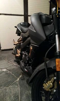 a black motorcycle parked in front of a garage door