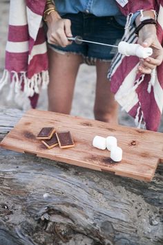 a person cutting marshmallows on a wooden board