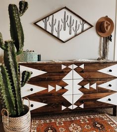 a large cactus sitting on top of a wooden dresser next to a mirror and rug