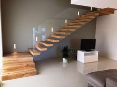 a living room filled with furniture and a stair case next to a flat screen tv