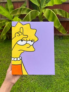 a hand holding up a piece of paper with the simpsons face on it