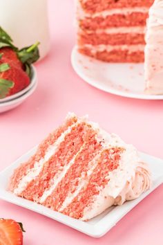 a slice of red velvet cake with white frosting and strawberries on the side