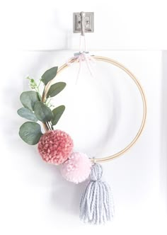 a wreath with two pom - poms hanging from it