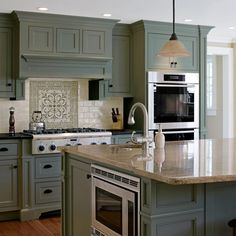 a kitchen with green cabinets and an oven