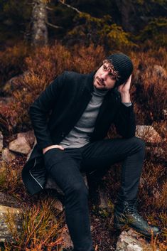 a man sitting on top of a pile of rocks