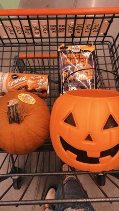 a shopping cart filled with pumpkins and snacks