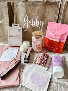 the contents of a personal care bag laid out on a bed next to a shopping bag