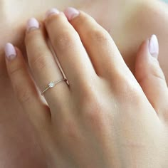 a woman's hand with a diamond ring on it