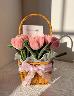 a small basket with pink flowers and a card