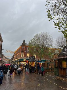 people are walking down the street on a rainy day