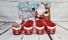 a group of red boxes with santa clause on them sitting in front of a white brick wall