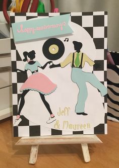 a card with an image of two people dancing on a checkered background and the words happy anniversary