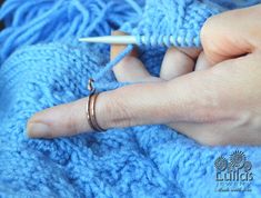 a person is knitting with a crochet hook on the end of their finger