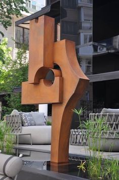 a large wooden sculpture sitting in the middle of a park next to couches and tables