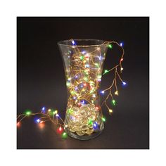 a glass vase filled with christmas lights on top of a table