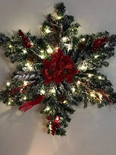 a christmas wreath with lights and poinsettis