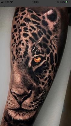 a man's arm with a tattoo of a leopard on it and an orange eye