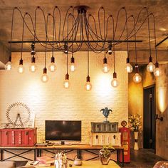 a living room filled with furniture and lots of light bulbs hanging from the ceiling above