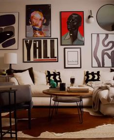 a living room filled with furniture and pictures on the wall above it's coffee table