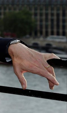 a man's hand on top of a railing