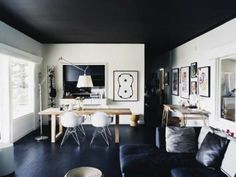 a living room filled with furniture and pictures on the wall next to a dining table