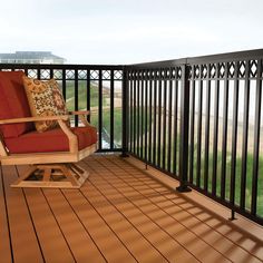 a rocking chair sitting on top of a wooden deck next to a railing and grass