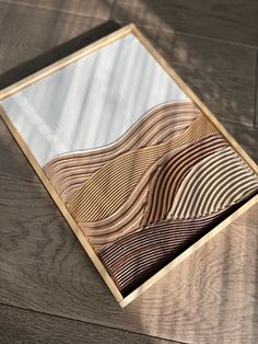 a wooden table with a mirror on top of it that has wavy lines in the wood