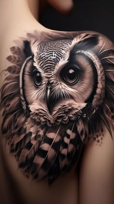 an owl tattoo on the back of a woman's shoulder