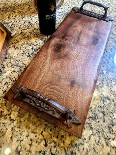 a wooden cutting board sitting on top of a counter next to a bottle of wine