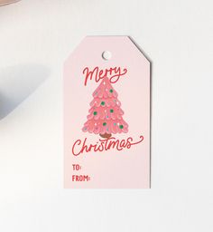 a pink christmas tree gift tag with the words merry christmas to from on it's side