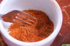 a white bowl filled with spices on top of a table