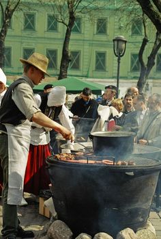 people are gathered around an outdoor bbq grill