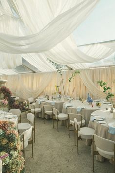 a banquet hall with tables and chairs covered in white draping