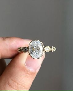 a person holding a ring with a diamond in it's center and two diamonds on the side