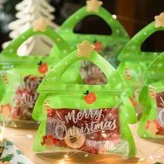 three bags filled with christmas candy sitting on top of a table next to other items