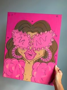 a person holding up a painting with pink and brown designs on it's face