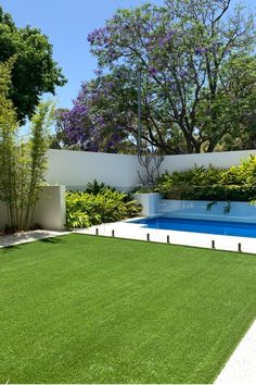 an empty swimming pool surrounded by lush green grass