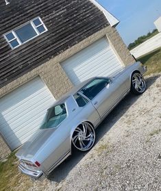 a silver car parked in front of a garage