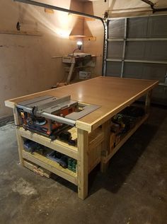 an unfinished workbench in a garage with tools on the table and lights on