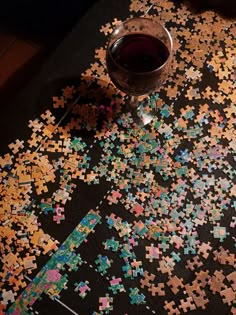 a glass of wine sitting on top of a puzzle