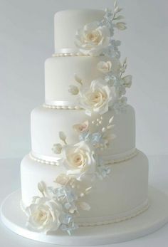 a three tiered white wedding cake with flowers on it