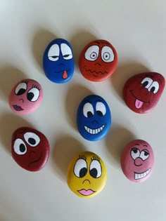 six different colored rocks with cartoon faces on them